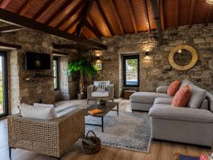 a living room with two couches and a stone wall at Open Space com Jacuzzi a 5 mn do centro de Lamego in Lamego