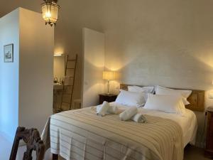 a bedroom with a large white bed with two pillows at Domaine des Druides in Apt