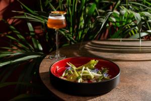 a bowl of food next to a glass of wine at Enterprise Hotel Design & Boutique in Milan