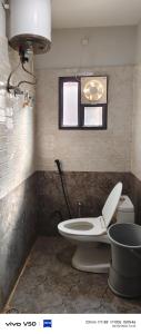 a bathroom with a toilet and a window at Shree radhe palace in Datia