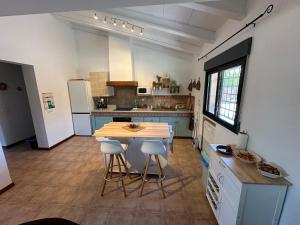 a kitchen with a table and two stools at Casa en la naturaleza de Chella in Chella