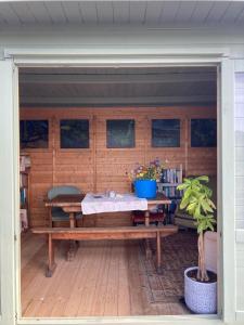 a wooden patio with a table and a bench at Apuldram Roses in Appledram