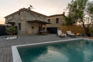 a backyard with a swimming pool and a house at Olea Stone Villa in Pylos