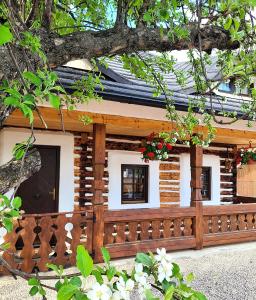 a log cabin with a wooden fence and flowers at Cerdacul cu Amintiri in Câmpulung Moldovenesc