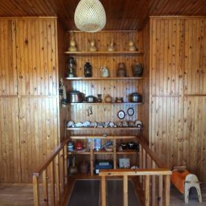 a room with wooden walls and shelves with pots and pans at Rising Sun Guesthouse in Mesokhória +25 photos