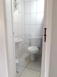 a white bathroom with a toilet and a sink at Hospedagem 154 Colonial in Gramado
