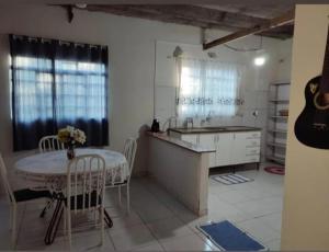 a kitchen with a table and a sink and a table and chairs at Hostel Pachamama in Presidente Prudente