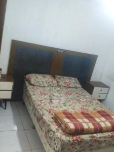 a bedroom with a bed with a wooden head board at Hostel Pachamama in Presidente Prudente