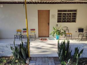 a patio with chairs and tables and a door at Hostel Pachamama in Presidente Prudente