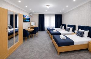 a hotel room with three beds and a desk at Sultanahmet Hotel in Baku