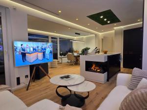 a living room with a tv and a fireplace at Förde Loge - Traumblick & Spa in Glücksburg +33 photos