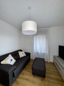 a living room with a black couch and a chandelier at Appartamento alla Lupa in Vetriola