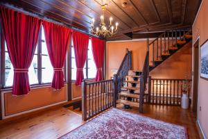 a living room with red curtains and a staircase at RAHAT Guest House in Old Town - Free Private Parking in Plovdiv