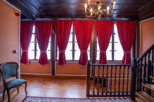 a room with red curtains and a chandelier at RAHAT Guest House in Old Town - Free Private Parking in Plovdiv