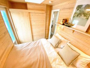 a bedroom with a bed in a room with wooden walls at Hausboot Yara am Steg 1D in Heiligenhafen +16 photos