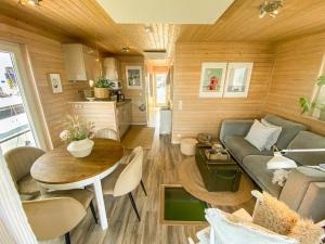 a living room with a couch and a table at Hausboot Yara am Steg 1D in Heiligenhafen