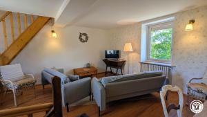 a living room with two couches and a television at Le Brocangîte à Jules - 4 pers in Bèze