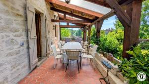 an outdoor patio with a table and chairs at Le Brocangîte à Jules - 4 pers in Bèze
