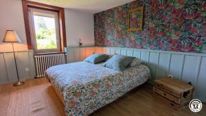 a bedroom with a bed and a window and a painting at Le Brocangîte à Jules - 4 pers in Bèze