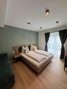 a bedroom with a large bed and a large window at Ferienwohnung Hofblick in Krustetten