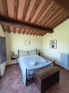 a bedroom with a bed and a wooden ceiling at Il poggio più 'n giù in Volterra