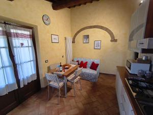 a kitchen with a table and chairs in a room at Il poggio più 'n giù in Volterra