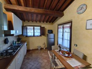 a kitchen with a refrigerator and a table in it at Il poggio più 'n giù in Volterra +31 photos
