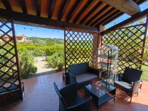 a screened in porch with a glass table and chairs at Il poggio più 'n giù in Volterra