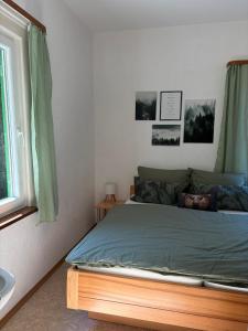a bedroom with a bed with green sheets and a window at Ferienhaus Hirschglück in Alpirsbach