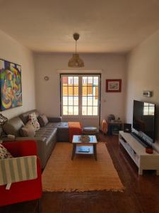a living room with a couch and a tv at Dunas Rest in Odemira