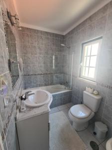 a bathroom with a sink and a toilet and a tub at Dunas Rest in Odemira +30 photos