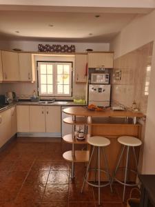 a kitchen with a counter and some stools in it at Dunas Rest in Odemira