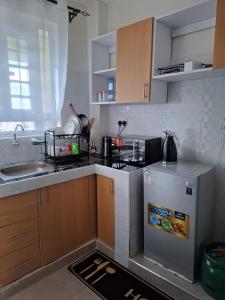 a small kitchen with a sink and a refrigerator at Serene 63 Luxe in Murangʼa
