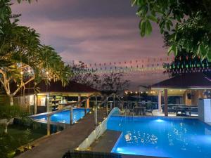a swimming pool at night with a hotel at Villa Marquez in Camotes Islands