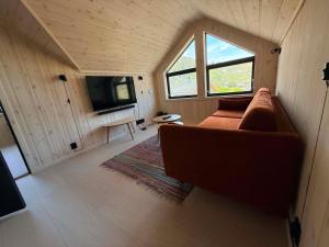 a living room with a couch and a tv at Chalet Glåpen in Moskenes