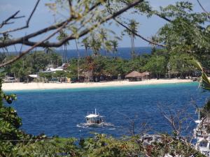 a boat in the water next to a beach at Villa Marquez in Camotes Islands