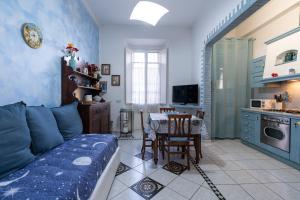a living room with a blue couch and a kitchen at Green Square Apartment 14 Min from Santa Croce with Hydromassage Tub in Florence