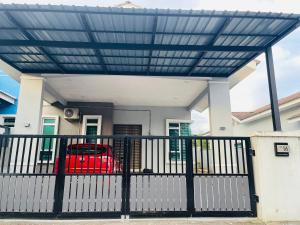 a pergola on a house with a red car at D Azlin Homestay in Kuala Kangsar