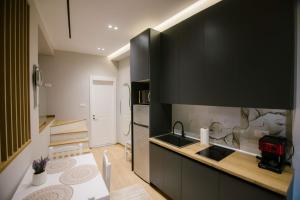 a kitchen with black cabinets and a counter top at Triple Nest Korce in Korçë
