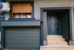 a house with two garage doors and a window at Triple Nest Korce in Korçë