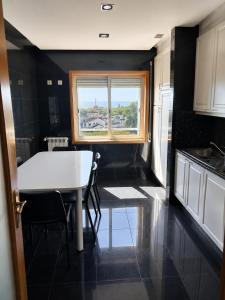 a kitchen with a white table and a window at PORTO AGUDA BEACH ***** in Arcozelo