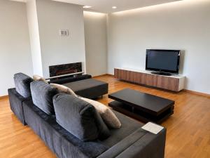 a living room with a couch and a flat screen tv at PORTO AGUDA BEACH ***** in Arcozelo