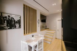 a dining room with a white table and some stairs at Triple Nest Korce in Korçë