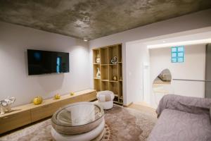 a living room with a bed and a tv at Triple Nest Korce in Korçë