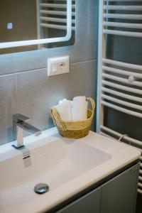 a bathroom with a basket of towels on a sink at Triple Nest Korce in Korçë +15 photos