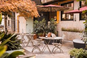 a group of tables and chairs with an umbrella at QC Room Milano Porta Romana in Milan