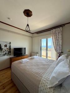 a bedroom with a bed and a tv and a window at Blue Horizon Balcony in Volos