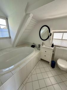 a white bathroom with a tub and a sink at Im Dörnchen in Mettmann +13 photos