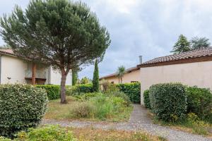 a house and a tree in a yard at Villa Léonidas - Conciergerieland in Léon