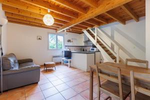 a living room with a couch and a table and a kitchen at Villa Léonidas - Conciergerieland in Léon